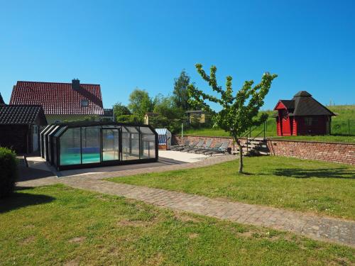 a glass house with a swimming pool in a yard at Villa Jenny mit Pool in Wohlenberg