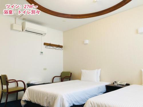 a hotel room with two beds and two chairs at Hotel Precia Naha Tsujimachi - Vacation STAY 17058v in Naha