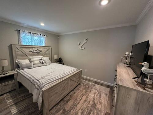 een slaapkamer met een groot bed en een televisie bij Lake Life in Huddleston