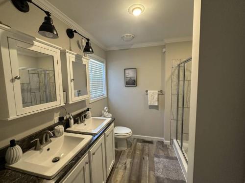 een badkamer met 2 wastafels en een toilet bij Lake Life in Huddleston