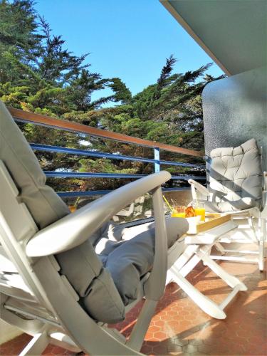 a pair of chairs sitting on a balcony at Le Capitole - Studio d'exception accès direct à la plage Benoît in La Baule