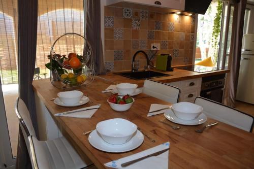a kitchen with a wooden table with plates and bowls at Loft El Ranch Playa a 10 minutos andando con Jacuzzi XXL y Jardin Privado in Calafell