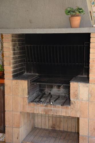 an outdoor brick oven with a plant on top at Loft El Ranch Playa a 10 minutos andando con Jacuzzi XXL y Jardin Privado in Calafell