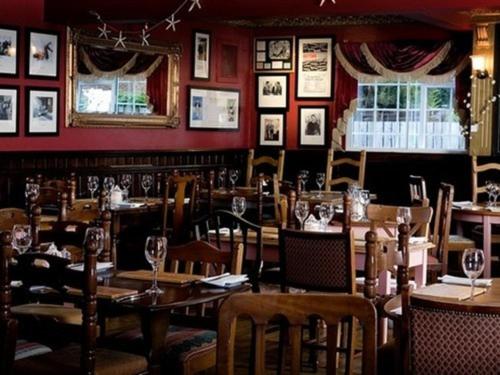 a restaurant with wooden tables and chairs and a red wall at The Lambton Worm in Chester-le-Street