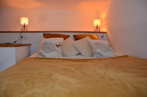 a bed with white pillows and two lamps on top at Loft El Ranch Playa a 10 minutos andando con Jacuzzi XXL y Jardin Privado in Calafell