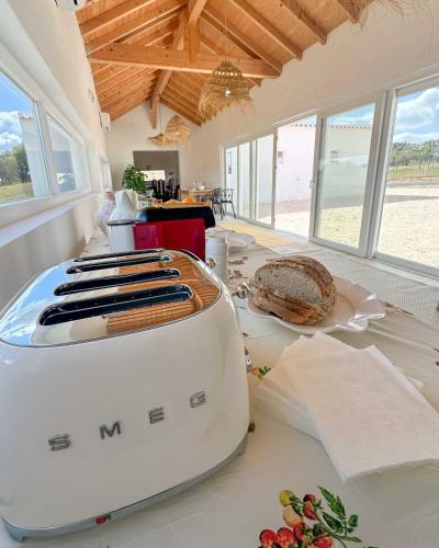 a toaster sitting on top of a table with bread at Valle D`Água - Casas de campo in Vale de Água