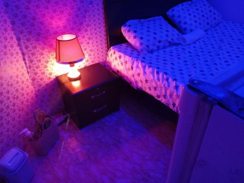 ein Schlafzimmer mit einem Bett und einer Lampe auf einem Nachttisch in der Unterkunft Khalidiya in Abu Dhabi