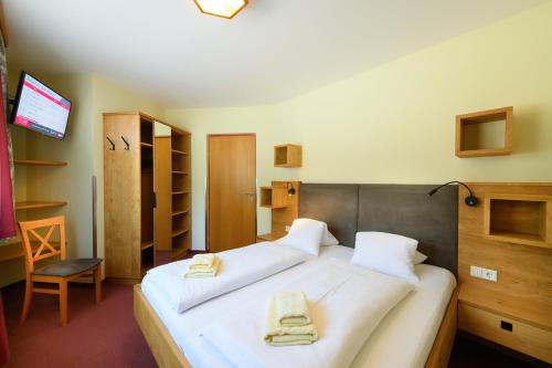a bedroom with a bed with two towels on it at Harmls Aparthotel in Flachau