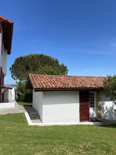 a small white building with a red roof at Calicho in Urrugne