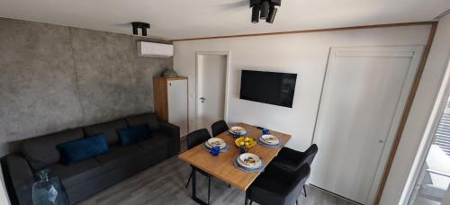 ein Wohnzimmer mit einem Tisch und einem Sofa in der Unterkunft Adriaticoast Holiday Apartments- Blue Horizon in Drage