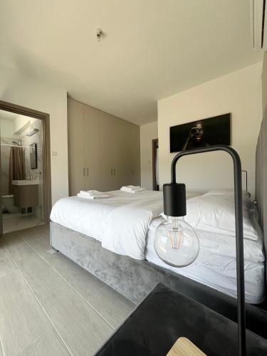 a bedroom with a large white bed with a lamp at Hubstay - Seaview Villa Oriana in Larnaca, 10 min Walk to the Beach in Larnaka