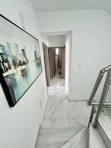 a staircase in a white room with a picture on the wall at Hubstay - Seaview Villa Oriana in Larnaca, 10 min Walk to the Beach in Larnaka