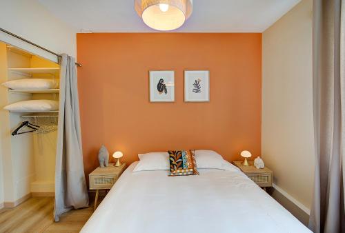 a bedroom with an orange wall and a bed at L'oeillet - Place Plumereau in Tours