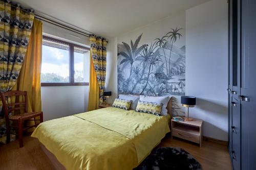 une chambre avec un lit avec un couvre-lit jaune dans l'établissement Prince - À 500m de la plage, à Courseulles-sur-Mer