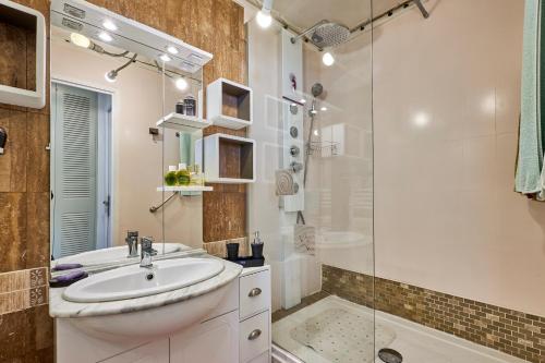 une salle de bain blanche avec un lavabo et une douche dans l'établissement Prince - À 500m de la plage, à Courseulles-sur-Mer