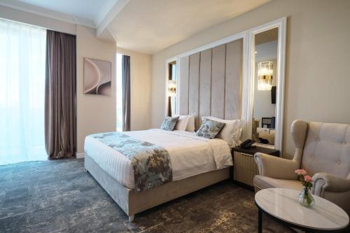 a hotel room with a bed and a chair at Panoramic Mamaia Hotel in Mamaia