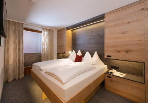 a bedroom with a large bed and a telephone at Harmls Aparthotel in Flachau
