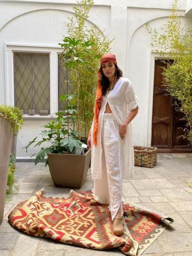 a woman standing next to a rug on the ground at In pieno centro storico Ca Marì e Casa Elena in Moncalvo