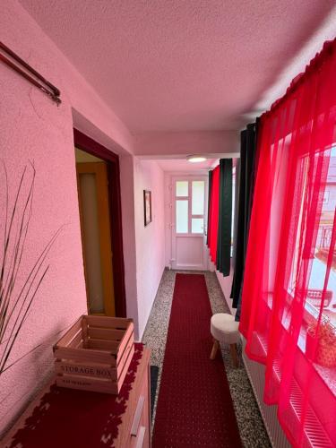 a hallway with pink walls and a red carpet at Studio Apartman Josip in Gospić