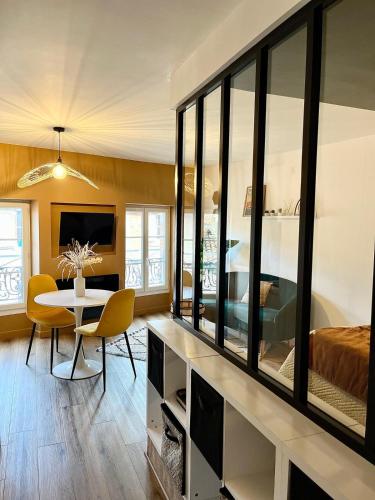 un salon avec une table à manger et une chambre dans l'établissement L'élégance, à Albi