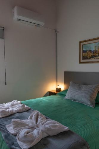 a bedroom with a green bed with a fan at Punto Golondrina in Alta Gracia