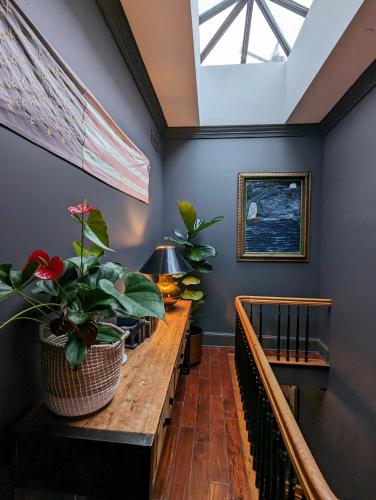 a hallway with a wooden table with plants on it at Wm. Farmer and Sons in Hudson