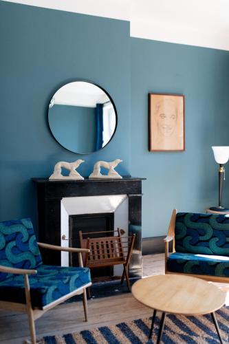 - un salon avec des murs bleus et un miroir dans l'établissement Le 5 - maison de style centre ville Normandie, à Eu