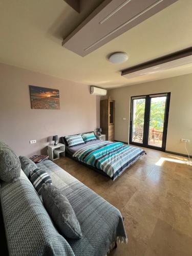 a bedroom with two beds and a large window at Cabana Maya in Corbu