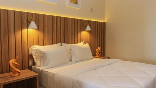 ein Schlafzimmer mit einem großen weißen Bett mit zwei Lampen in der Unterkunft Principe do Mutá Hotel Design in Santa Cruz Cabrália