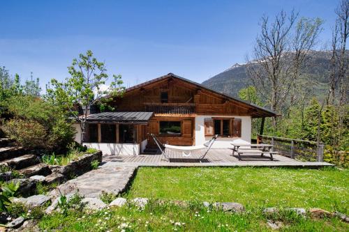 Cette maison en rondins dispose d'une terrasse et d'une cour. dans l'établissement Chalet Fleur de Lys - Chalet 4BR Wood Stove , Home Cinema , Parental Suite - By Cozee Rentals, aux Houches