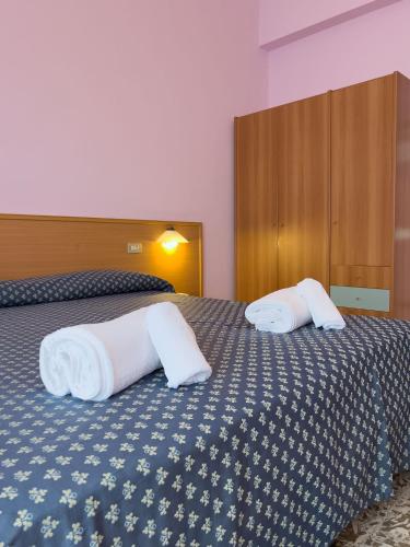 a bedroom with a bed with two pillows on it at Hotel Benacus Torri del Benaco in Torri del Benaco