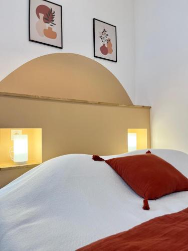 a bedroom with a white bed with a red pillow at L'écrin Albigeois in Albi