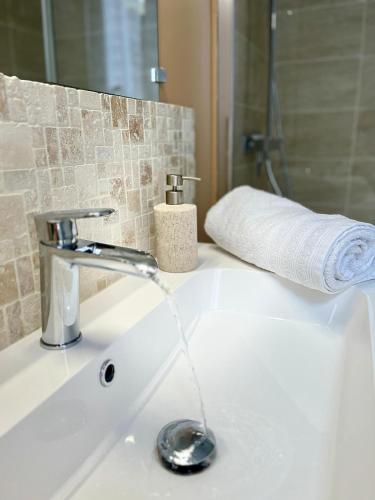 un lavabo de salle de bain avec un robinet et une serviette dans l'établissement L'écrin Albigeois, à Albi