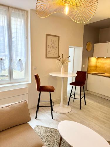 un salon avec une table et deux chaises dans l'établissement L'écrin Albigeois, à Albi