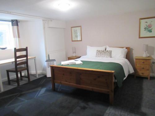 a bedroom with a bed and a desk and a chair at Captain Howey Hotel in New Romney