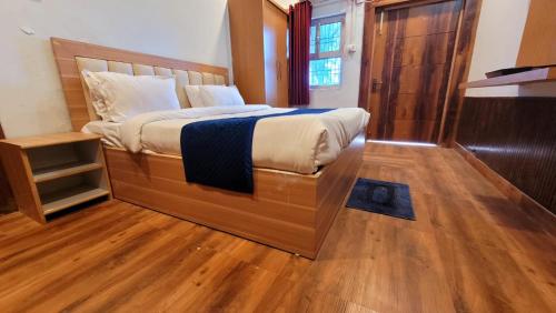 溫達文的住宿－Swastik Resort Vrindavan，一间卧室设有一张大床,铺有木地板