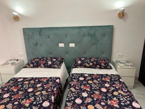 a bedroom with two beds and a green headboard at Guesthouse Dahlia Rossa in Rome