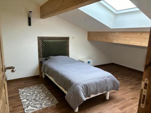 Cet appartement comprend une chambre dotée d'un lit et d'une lucarne. dans l'établissement Le campagnol, à Morgemoulin