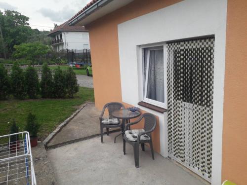 a patio with two chairs and a table and a window at Apartmani Zivkovic Ribarska banja in Ribarska Banja