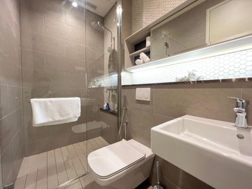 uma casa de banho com um WC branco e um lavatório. em Lucentia Suite by Westlife em Kuala Lumpur