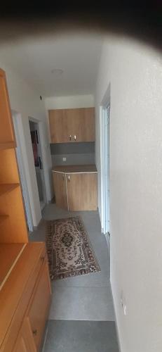 een lege kamer met een keuken met een tapijt bij Apartman Car in Prijepolje
