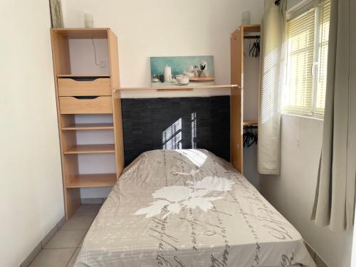 - une petite chambre avec un lit et une étagère dans l'établissement Maisonnette au calme, à Montauroux