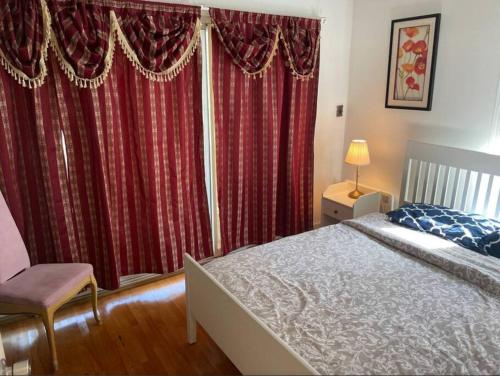 1 dormitorio con 1 cama y cortinas rojas en Beautiful 2 bedroom Apartment, en Montreal