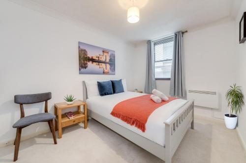 een slaapkamer met een bed, een stoel en een raam bij Luxury One Bedroom Apartment St Pauls Cathedral in Londen