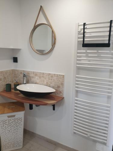 a bathroom with a sink and a mirror on the wall at Gîte proche de Sainte Mère Eglise in Montebourg