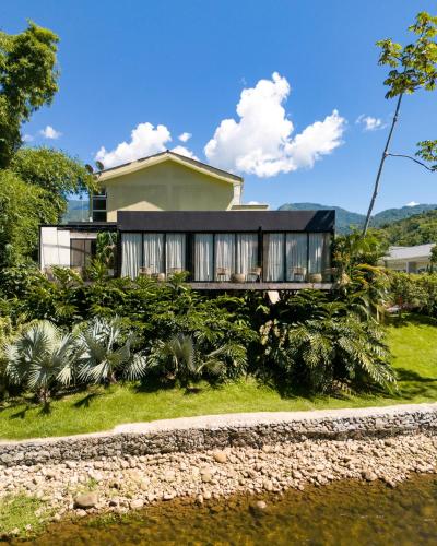a house with a black roof on top of a yard at Pousada Apple House Paraty in Paraty