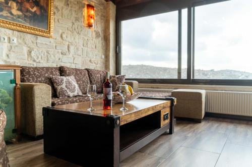 uma sala de estar com um sofá e uma mesa com copos de vinho em Villa Charaso Giorgio - private pool by Estia em Kharasón