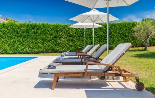 una fila di sedie a sdraio con ombrelloni accanto a una piscina di Rustic Villa Peran with outdoor pool in Tinjan a Radetići