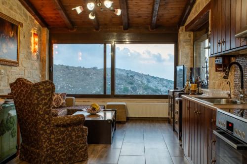uma cozinha com um sofá e uma grande janela em Villa Charaso Giorgio - private pool by Estia em Kharasón
