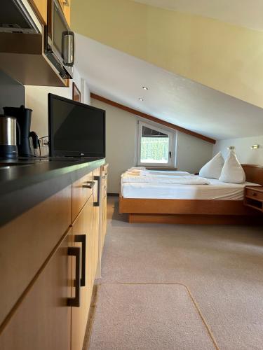 a bedroom with a bed and a flat screen tv at Harmls Aparthotel in Flachau